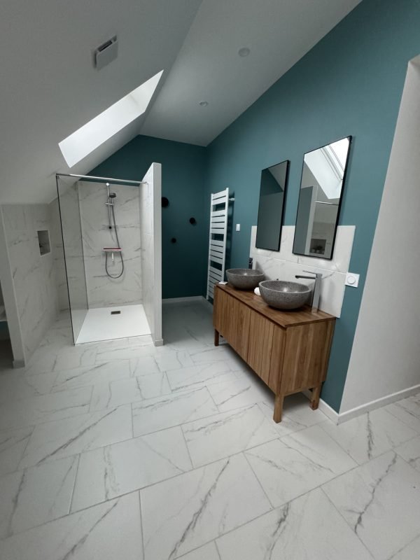 Salle de bain moderne rénovée avec douche italienne, double vasque et carrelage en marbre